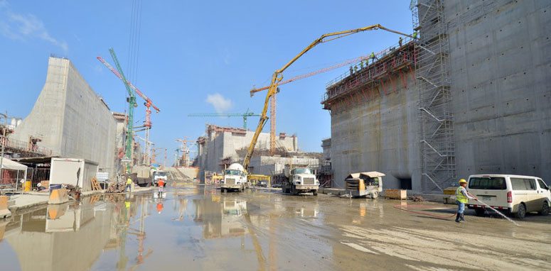 trucks working on large cement wall